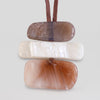 Three horizontal stone inlay pendants in brown, cream, and terracotta tones, suspended on a brown cord against a light gray background.