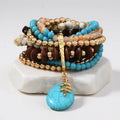 Stack of colorful beaded bracelets with a turquoise pendant on a white background
