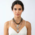 Woman wearing multiple necklaces on a white background