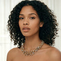 Gold necklace with small beads on a light beige background