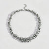 Silver necklace with black stones on a white background