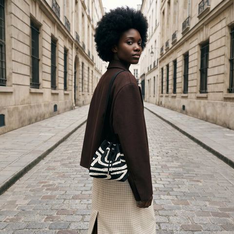 Woman walking down a city street with a patterned bag