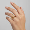 Hand wearing a gold ring on a plain background