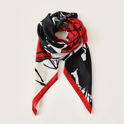Colorful scarf with black, red, and white pattern on a light gray background