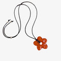 Butterfly-shaped amber pendant on a black cord against a white background