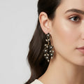 Close-up of a woman wearing a decorative earring on a plain background