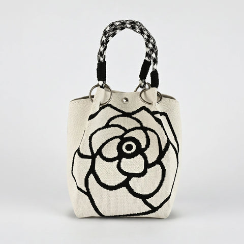 Handbag with a black floral design on a white background