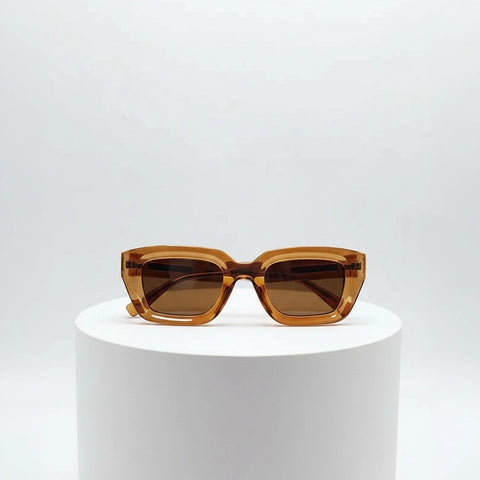 Brown sunglasses on a white pedestal against a light gray background