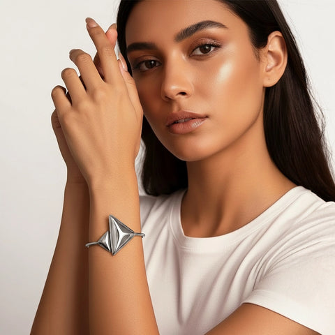 Woman wearing a silver bracelet on a plain background