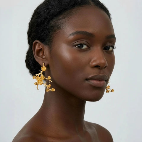 Woman wearing gold earrings against a neutral background
