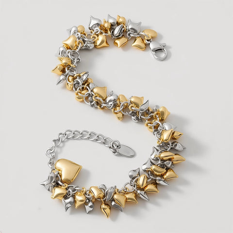 Gold and silver  heart-shaped bracelet on a light gray background