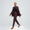 Woman wearing a brown suit with a black top on a white background