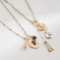 Gold and silver necklaces with various pendants on a light gray background