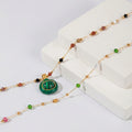 Necklace with a green pendant on a white surface