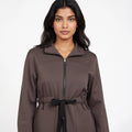 Woman wearing a brown coat with a white background