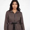 Woman wearing a brown coat with a white background