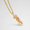 Gold and rose gold necklace with a unique pendant on a light gray background