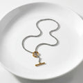 Necklace with a gold clasp on a white plate
