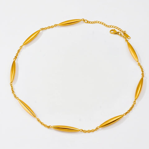 A gold chain necklace featuring seven elongated, polished oval links spaced evenly, displayed on a clean white background.