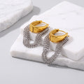 Pair of gold-tone hoop earrings accented with cascading silver chain tassels, styled on a white marble display block.