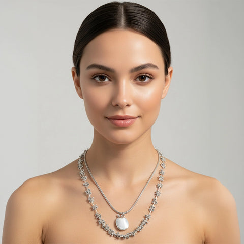 Woman wearing a silver necklace with a gray background