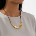 Gold crescent-shaped pendant on a white background