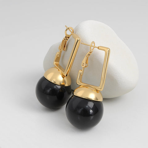 Gold and black earrings on a white background