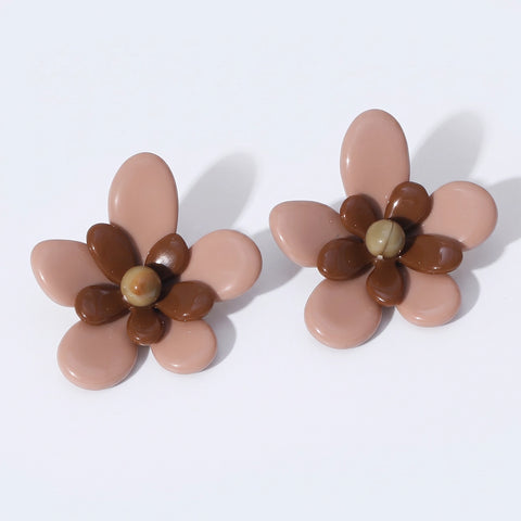 A pair of flower-shaped stud earrings with glossy dusty pink petals, dark brown center accents, and a small round beige bead in the middle, shown on a clean white background.