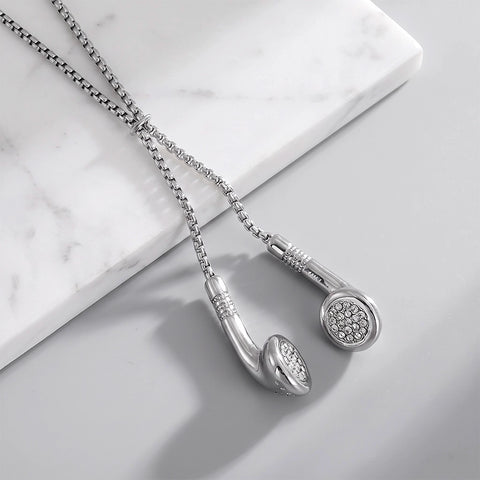 Silver slider necklaces with earbud-shaped pendant embellished with small clear stones, displayed on a light gray surface.