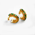 Gold hoop earrings with green gemstones on a white background