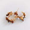 A pair of gold hoop earrings decorated with irregular brown amber stones, small white pearls, and tiny gold beads, displayed on a clean white background.