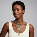 Woman wearing a necklace with a gray background