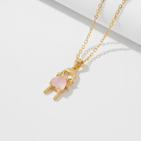 Gold necklace with a pink heart pendant on a white background