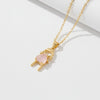 Gold necklace with a pink heart pendant on a white background