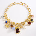 Gold bracelet with various charms on a white background