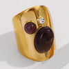 Gold ring with purple stones and a diamond on a white background